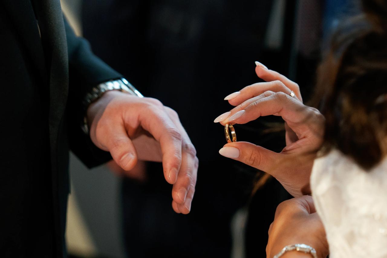 Close-up of a ringed hand gesture between two people in dim event lighting, with shallow depth of field. Wedding photography at Tribeca Rooftop + 360°, New York, NY.