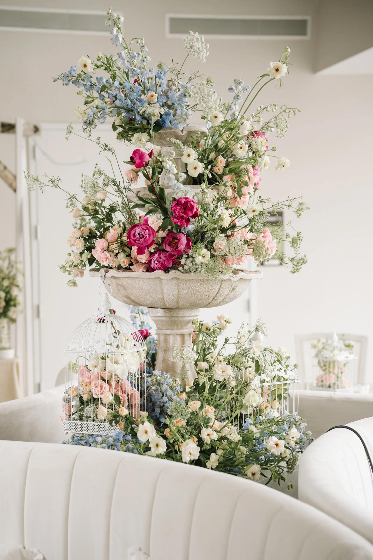 A tall pink-and-white floral centerpiece with decorative birdcage accents at the bar mitzvah reception. Bar Mitzvah photography at Hilton Garden Inn Springfield, Springfield, NJ.