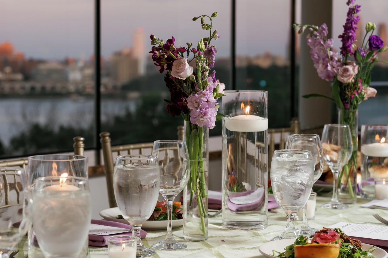 Candles and flowers on a reception table, with soft window light in the background. Wedding photography at Riverview Ballroom, Cliffside Park, NJ.