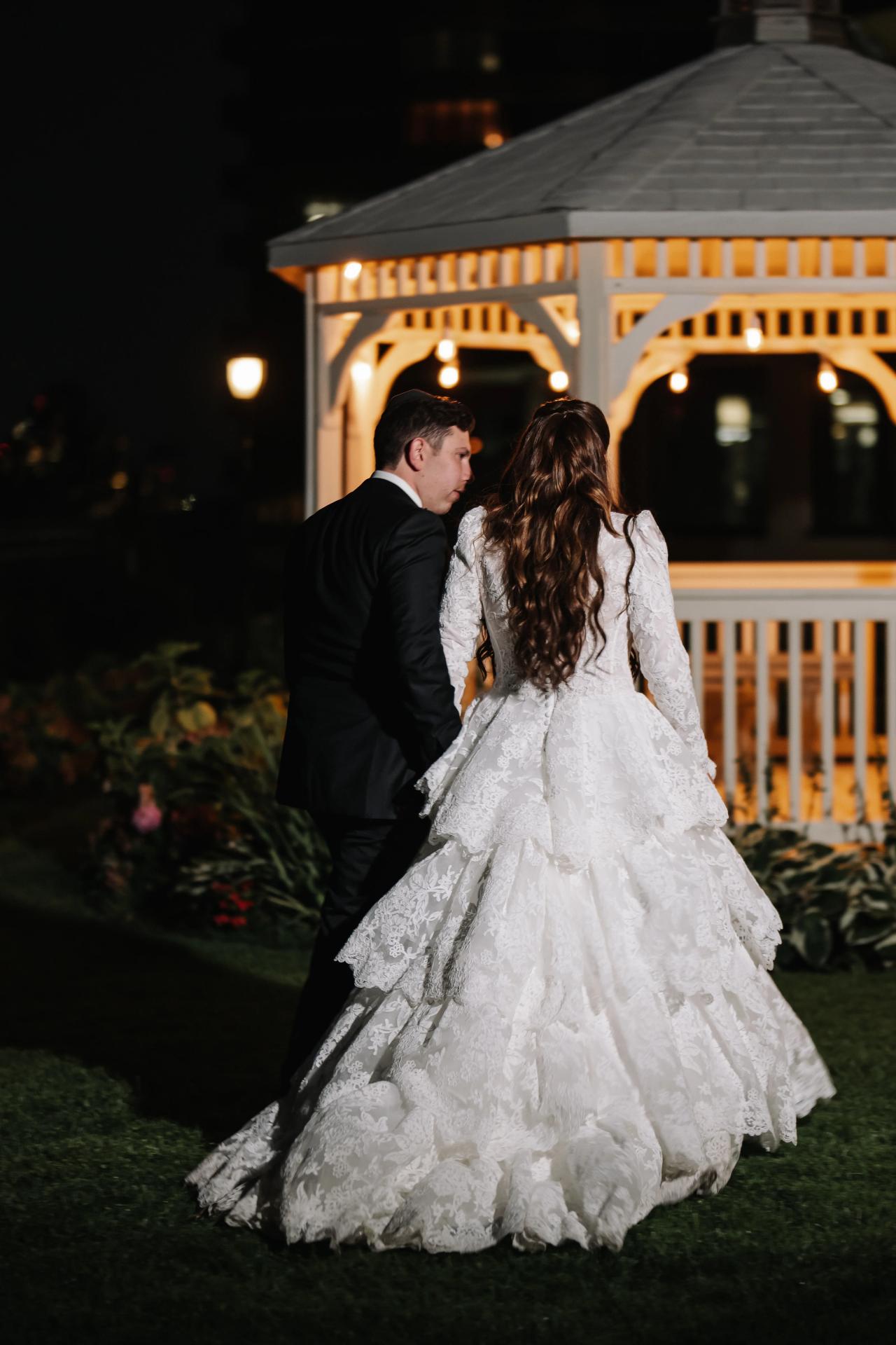 A quiet close portrait of the newlyweds beneath a warmly lit garden gazebo. Wedding photography at Riverview Ballroom, Cliffside Park, NJ.