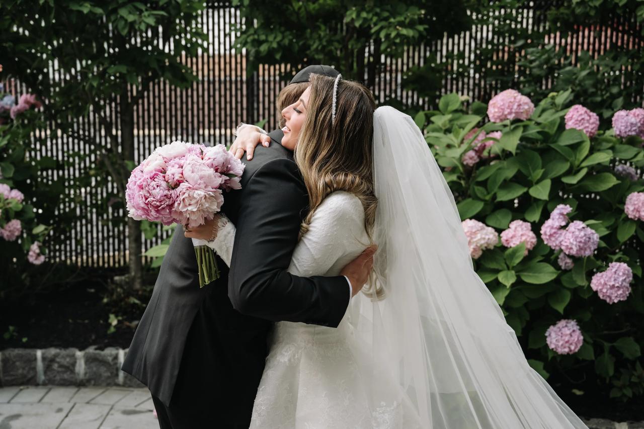 The bride and groom embrace and laugh during their outdoor first look. Wedding photography at Brightstone, Passaic, NJ.