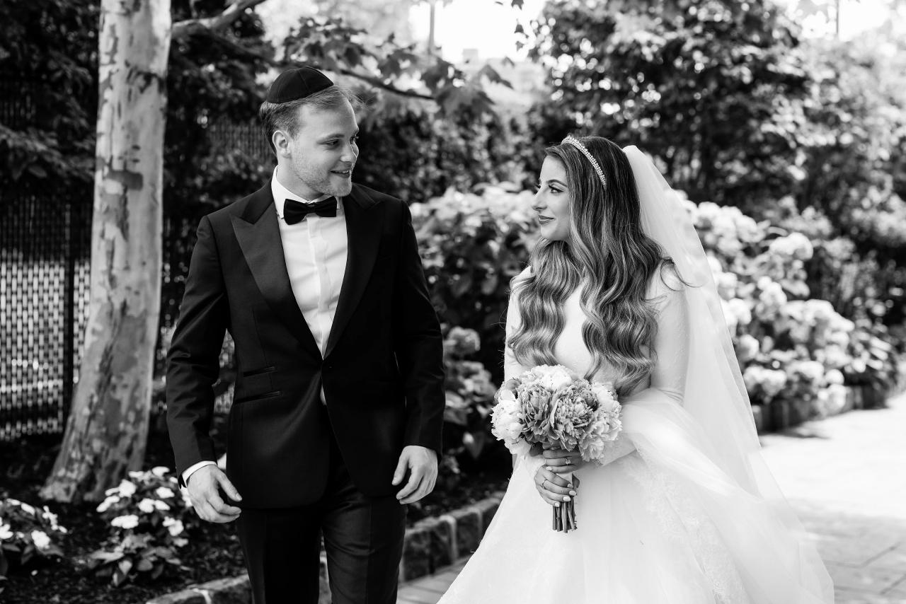 Black-and-white portrait of the couple laughing among hydrangeas. Wedding photography at Brightstone, Passaic, NJ.