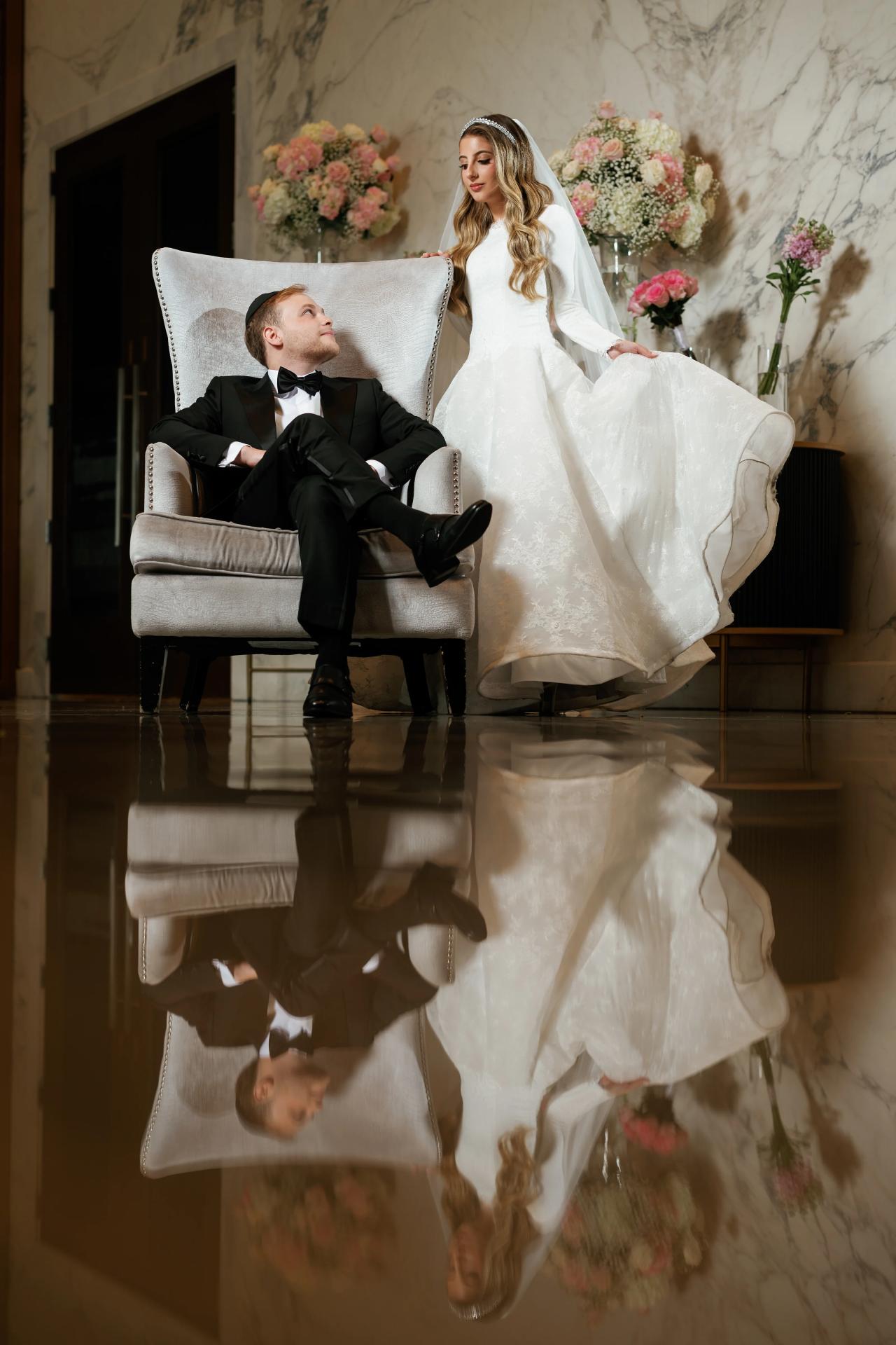Seated bride and groom reflected in a polished interior floor. Wedding photography at Brightstone, Passaic, NJ.
