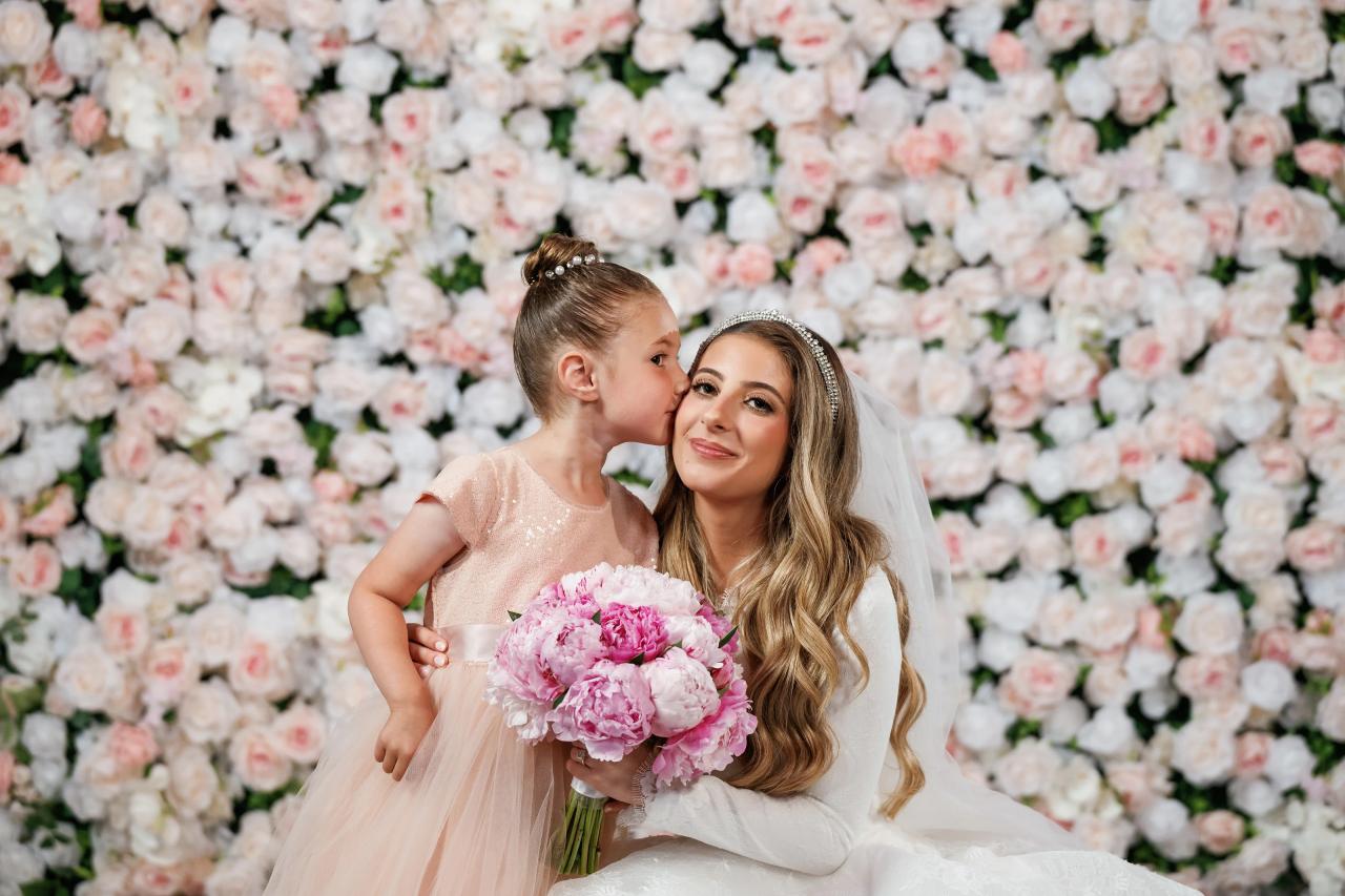 A young guest kisses the bride during a family moment. Wedding photography at Brightstone, Passaic, NJ.