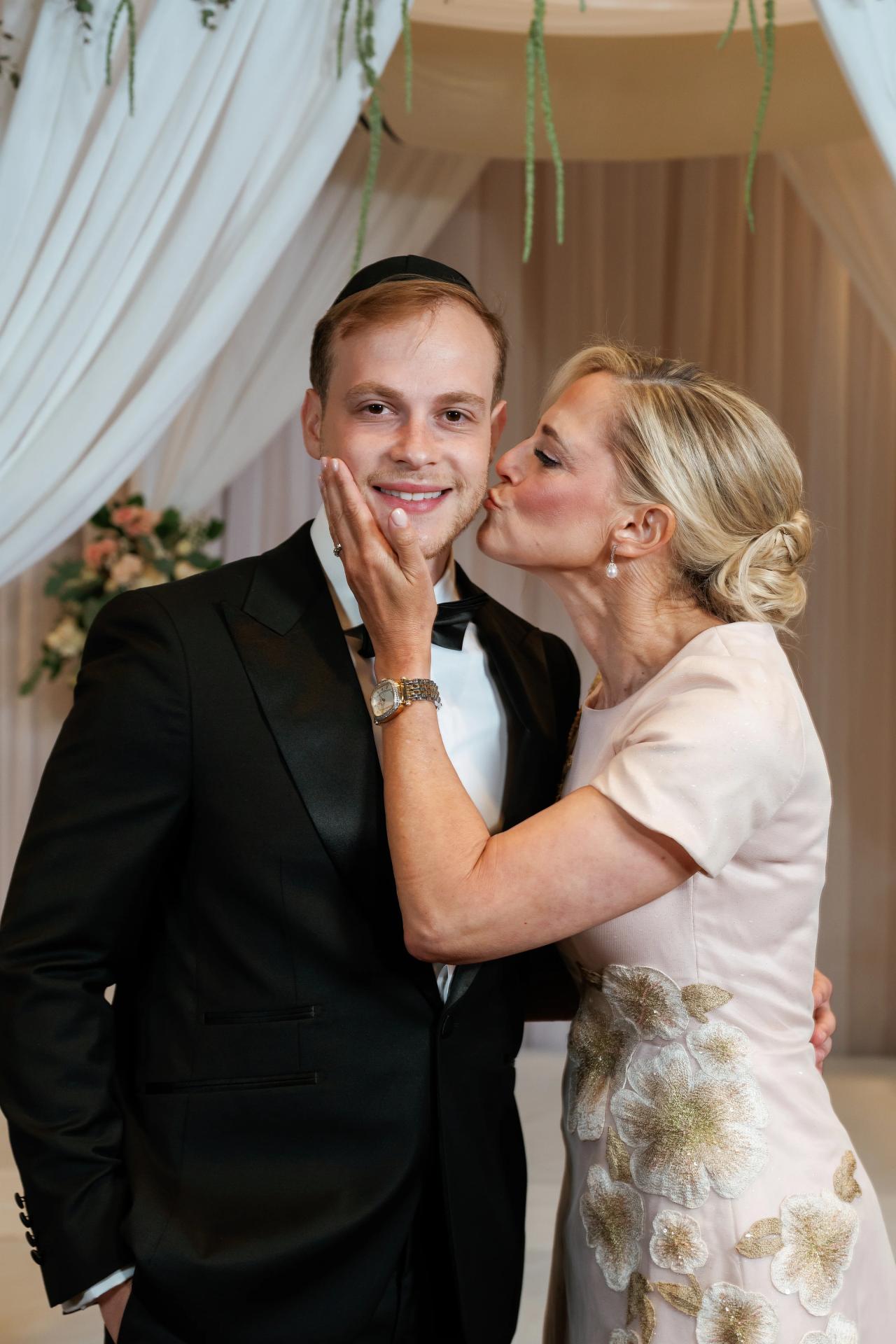 An affectionate family kiss with the groom. Wedding photography at Brightstone, Passaic, NJ.