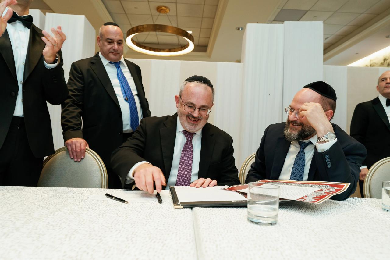 Guests and groom share a laugh during the wedding-document signing. Wedding photography at Brightstone, Passaic, NJ.