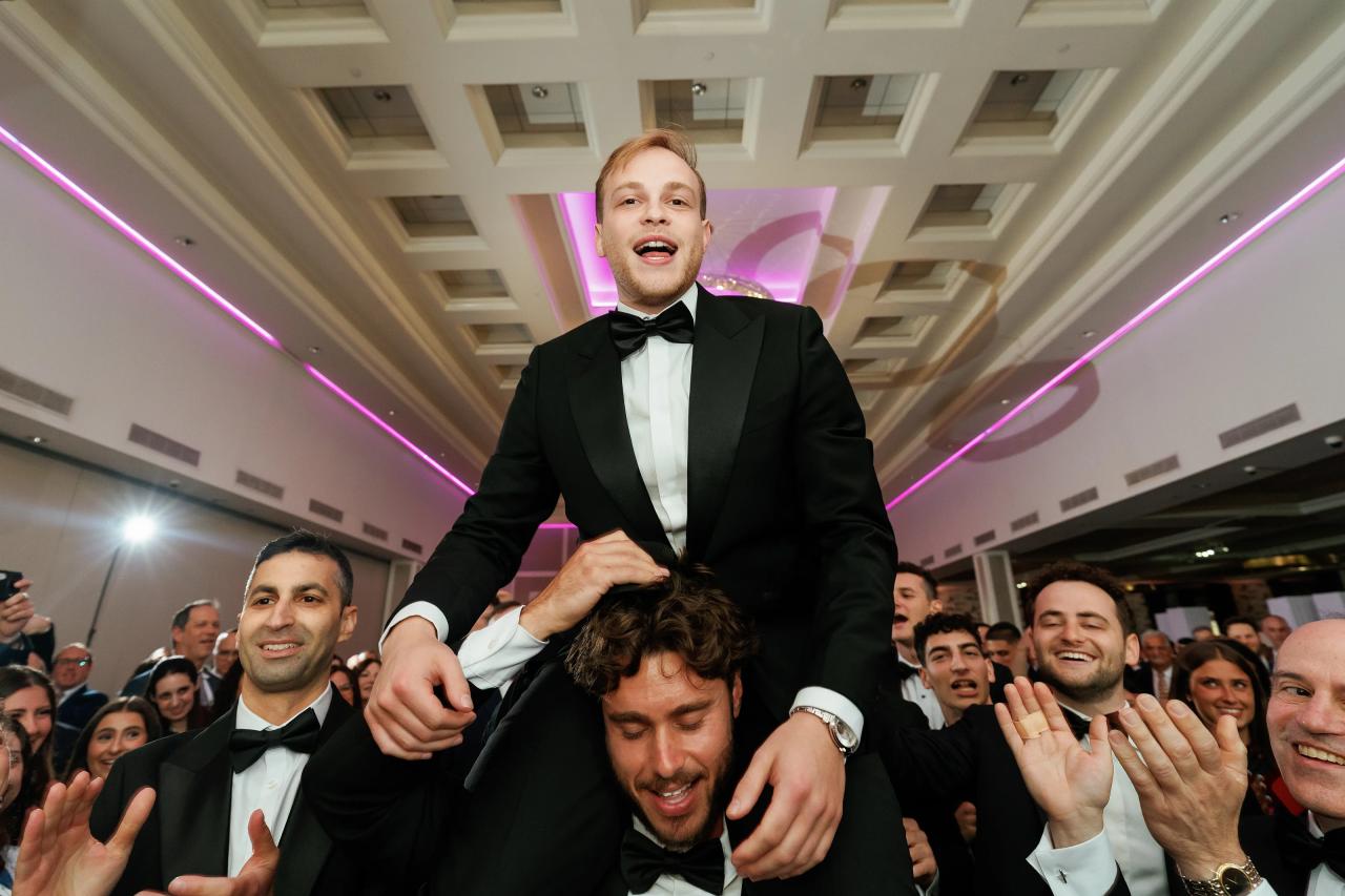 The groom lifted above a crowd of celebrating guests. Wedding photography at Brightstone, Passaic, NJ.