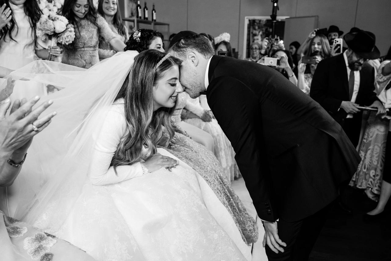 An affectionate black-and-white family kiss before the bedeken. Wedding photography at Brightstone, Passaic, NJ.