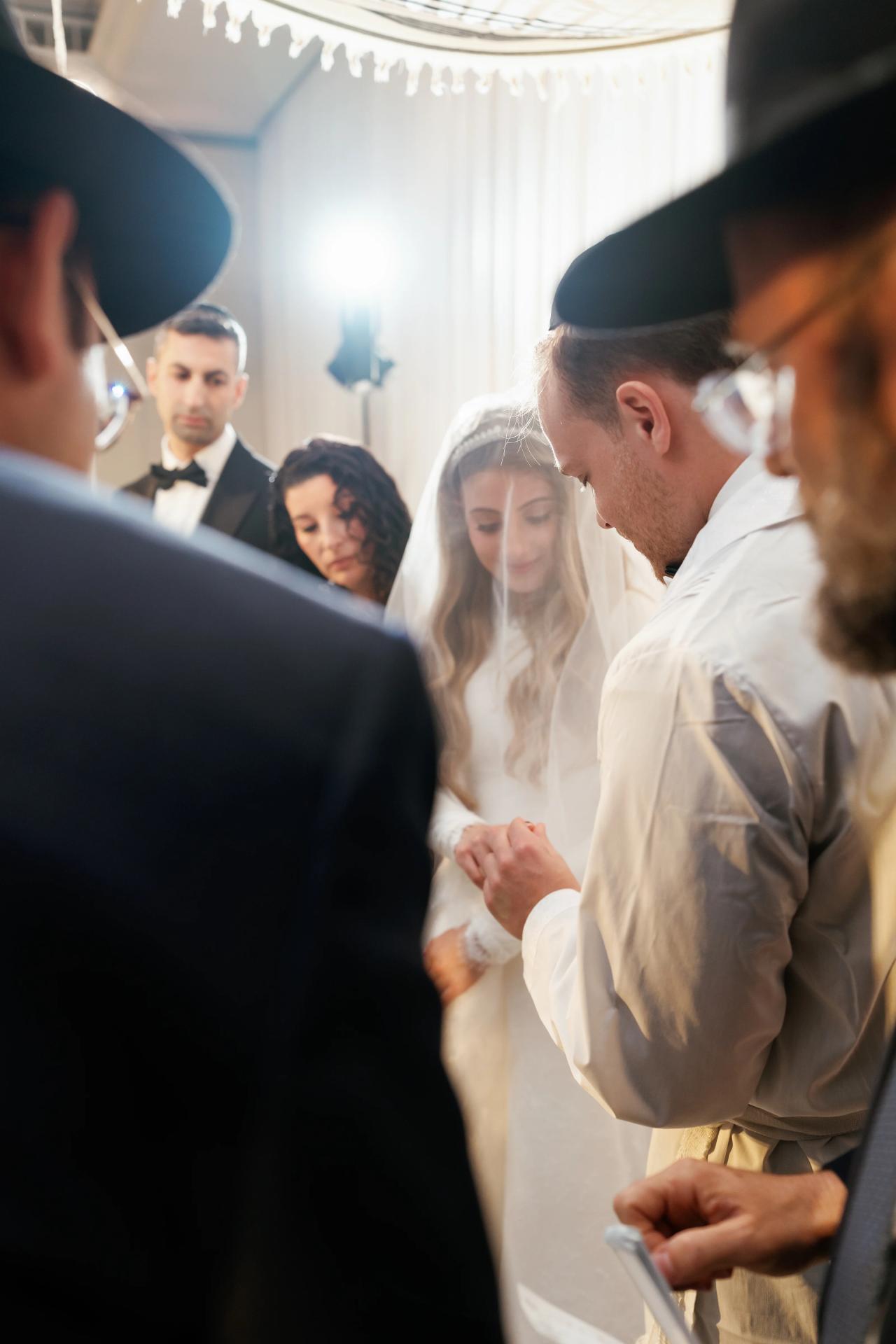 A layered ceremony photograph with light flare beneath the chuppah. Wedding photography at Brightstone, Passaic, NJ.