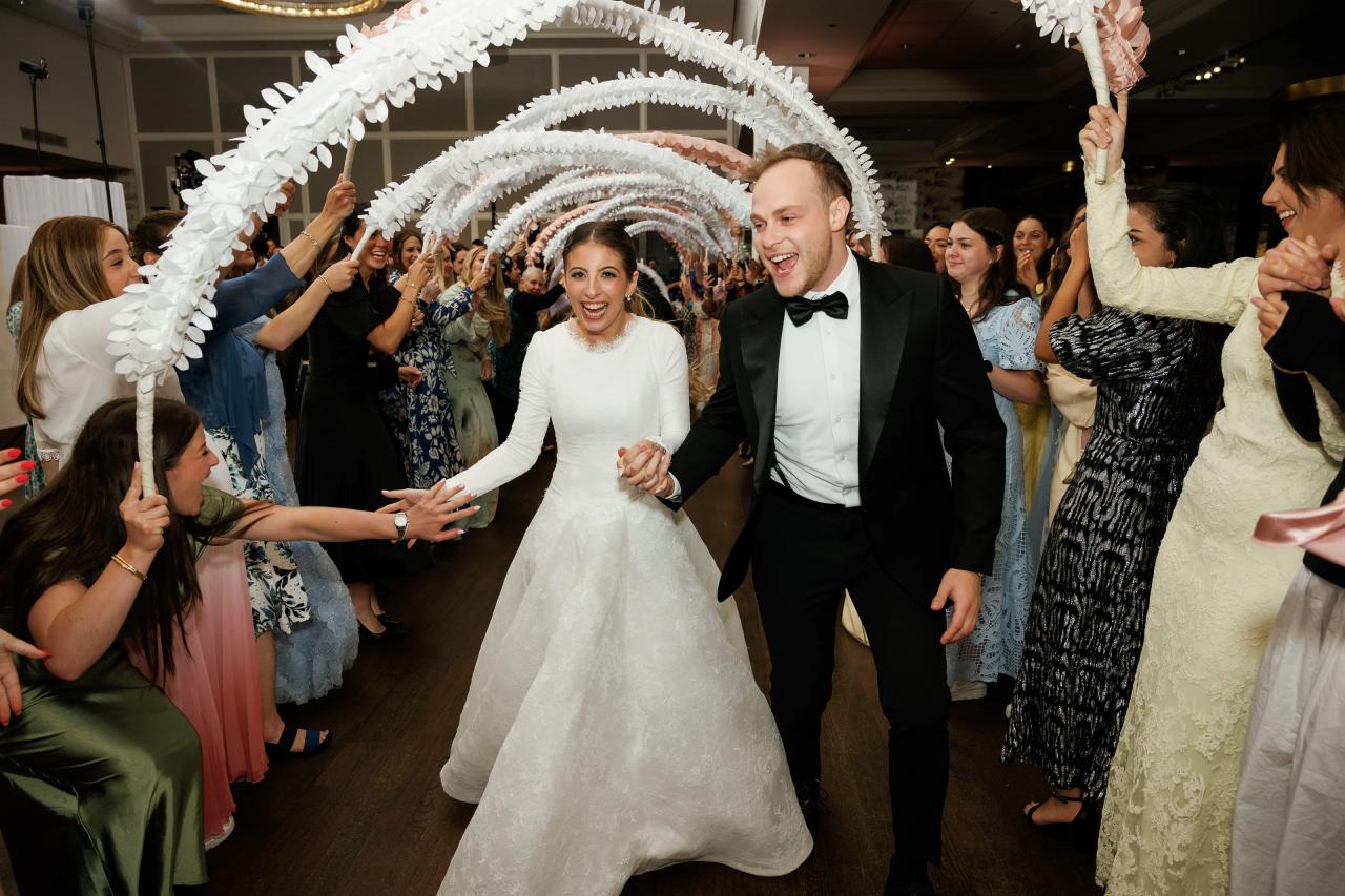 The couple enters the reception through a tunnel of raised celebration props. Wedding photography at Brightstone, Passaic, NJ.