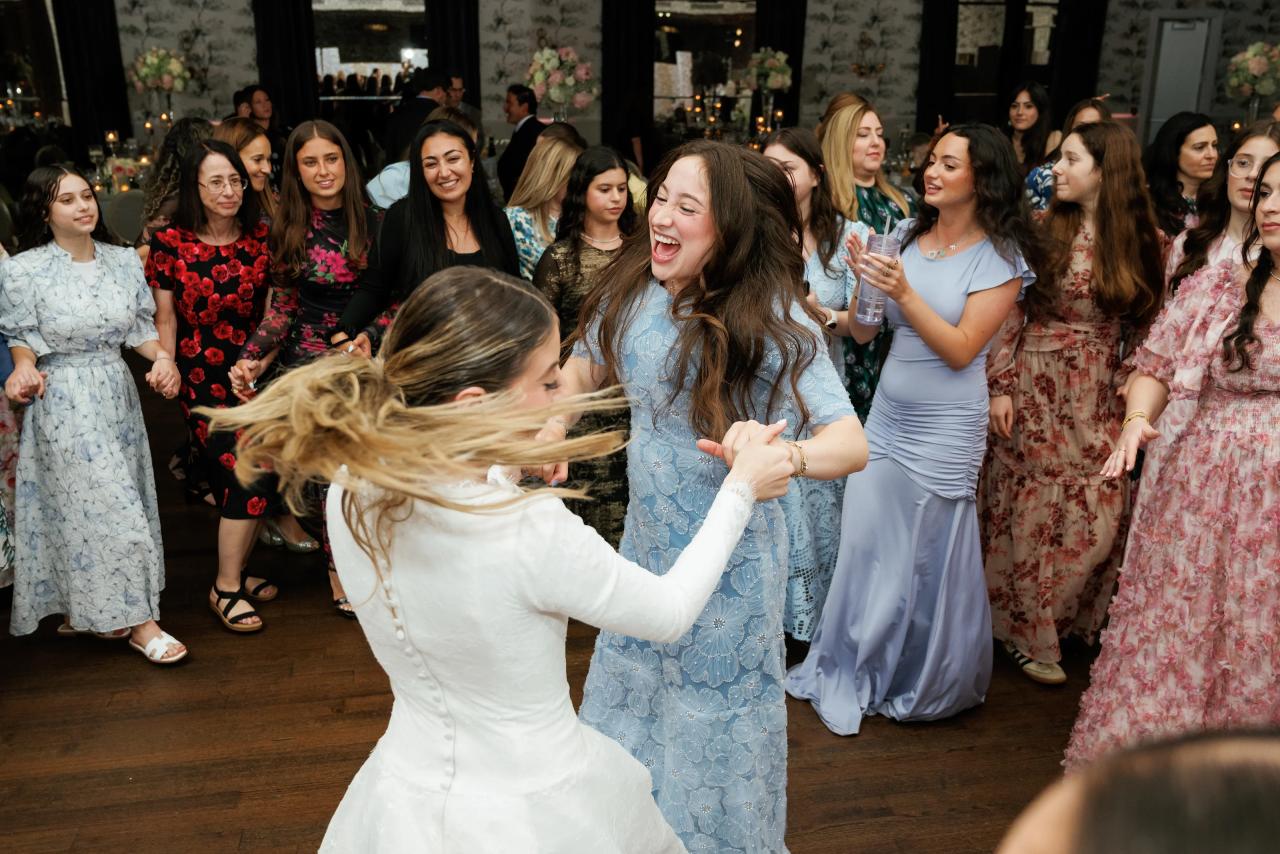 The bride’s hair and gown move as she dances with a guest. Wedding photography at Brightstone, Passaic, NJ.