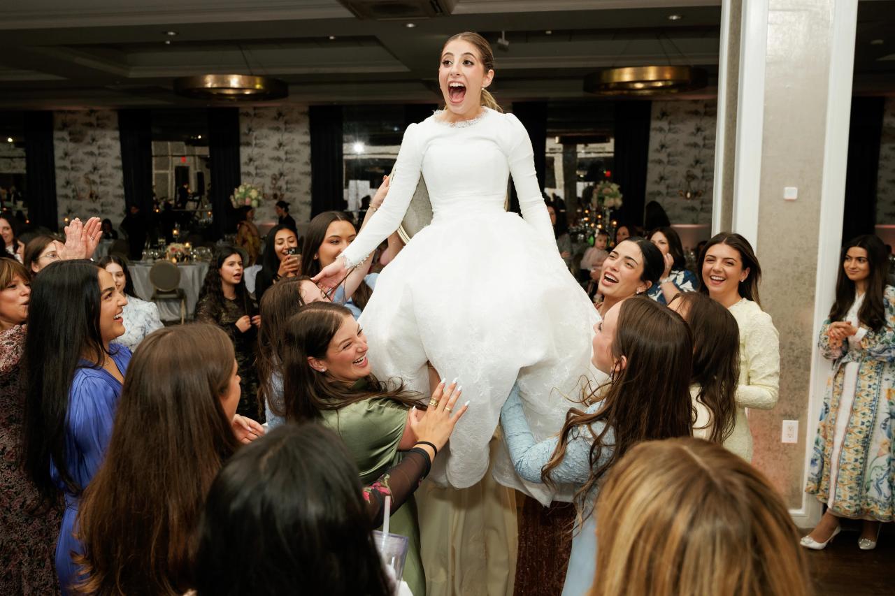 The bride lifted above the dance floor on a chair. Wedding photography at Brightstone, Passaic, NJ.