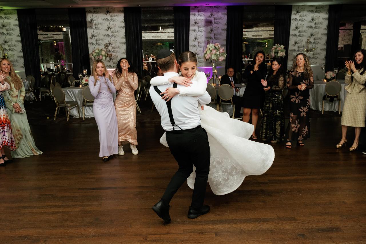 The groom carries the bride during the reception dancing. Wedding photography at Brightstone, Passaic, NJ.