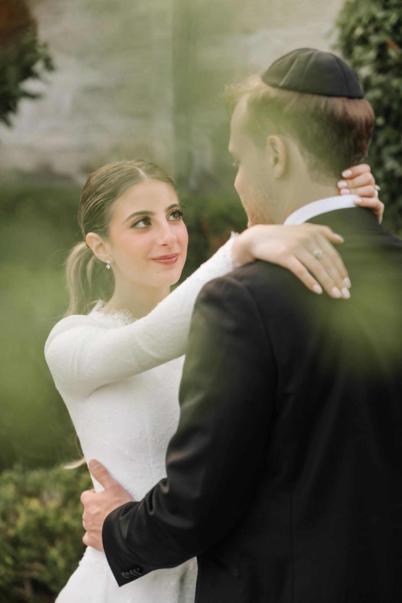 Soft leaves frame an intimate outdoor portrait of the bride and groom. Wedding photography at Brightstone, Passaic, NJ.