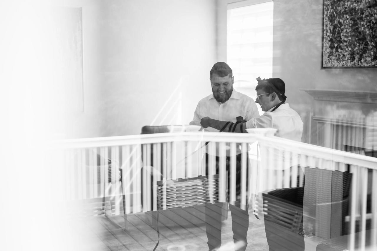 A black-and-white preparation moment framed through the foreground, before the Eagle Ridge bar mitzvah. Bar Mitzvah photography.
