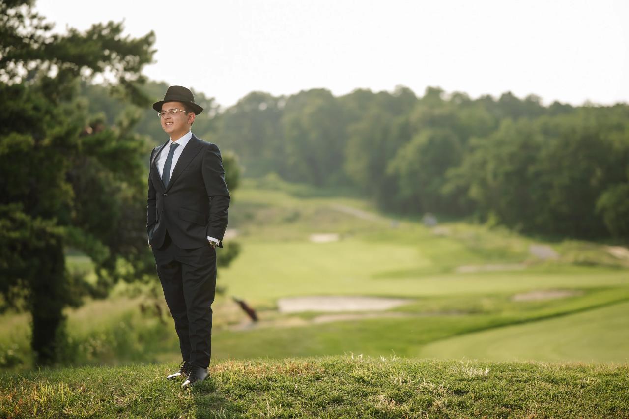 A wide portrait of the celebrant beside the golf-course landscape. Bar Mitzvah photography at Eagle Ridge, Lakewood, NJ.