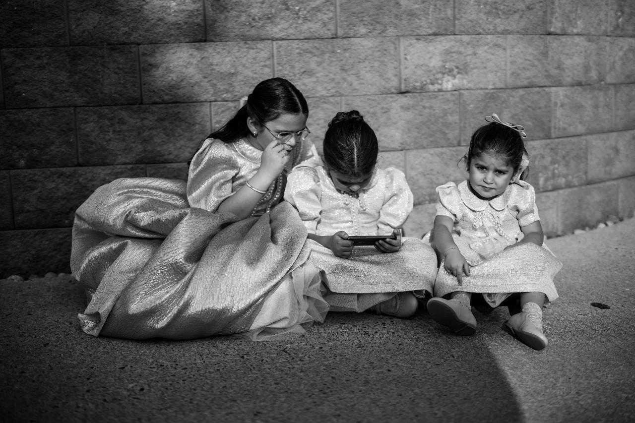 Children gather on the floor in a black-and-white family moment. Bar Mitzvah photography at Eagle Ridge, Lakewood, NJ.
