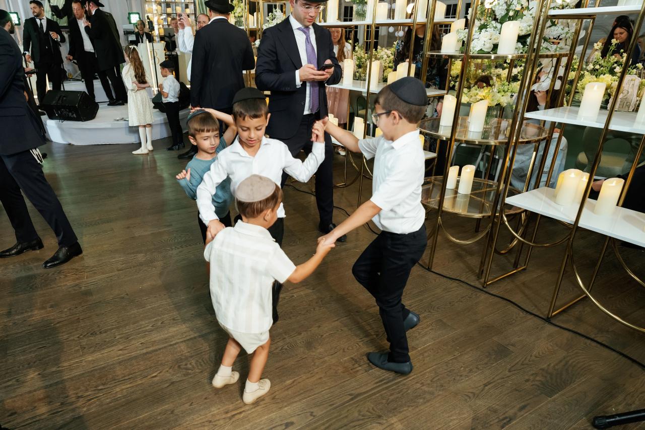 Children form a small dance circle during the celebration. Bar Mitzvah photography at Eagle Ridge, Lakewood, NJ.