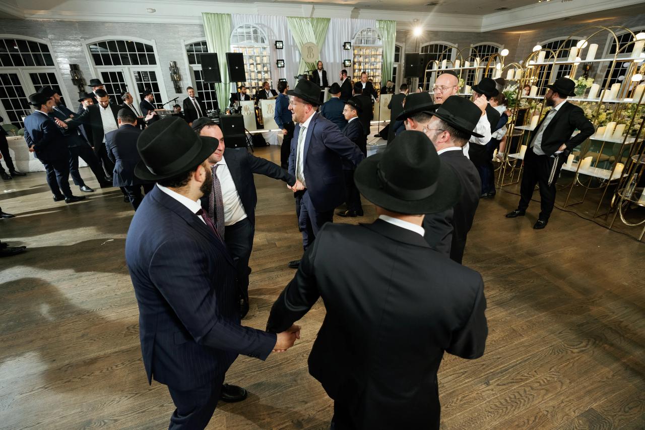 Linked dancers form a diagonal line across the reception floor. Bar Mitzvah photography at Eagle Ridge, Lakewood, NJ.