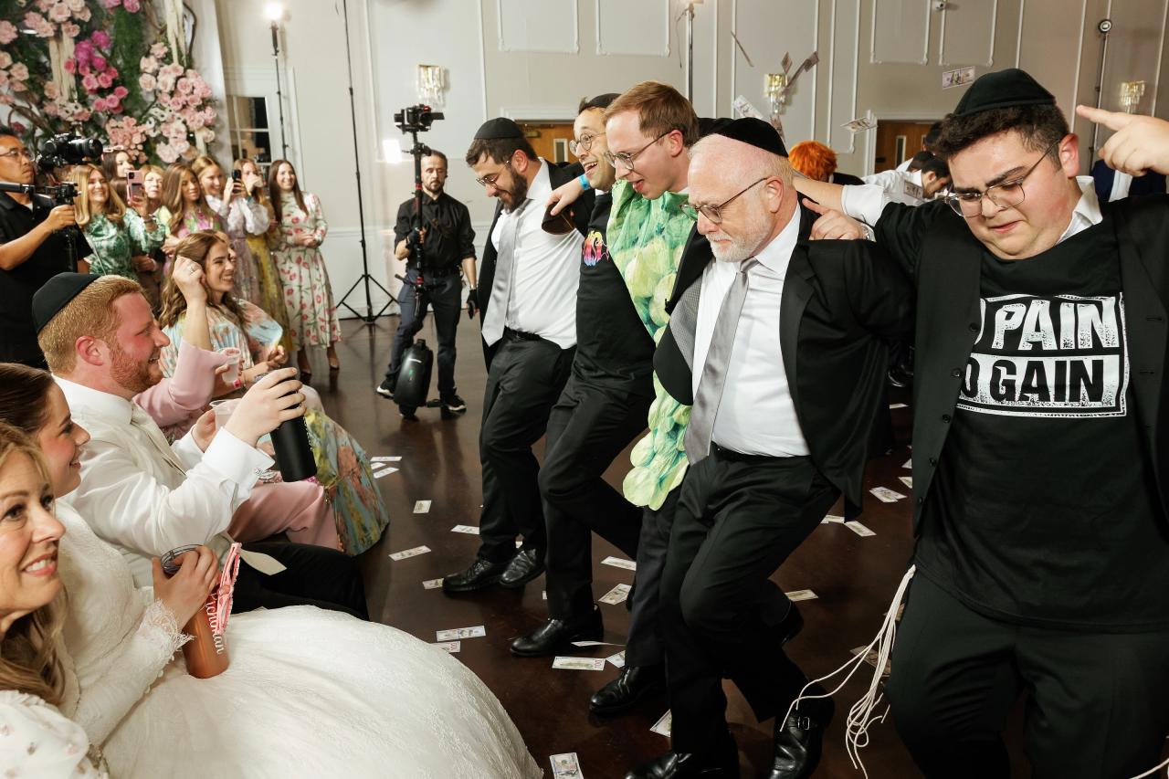 The groom lifted high above cheering guests on the wedding dance floor. Wedding photography at Ateres Charna, New Square, NY.