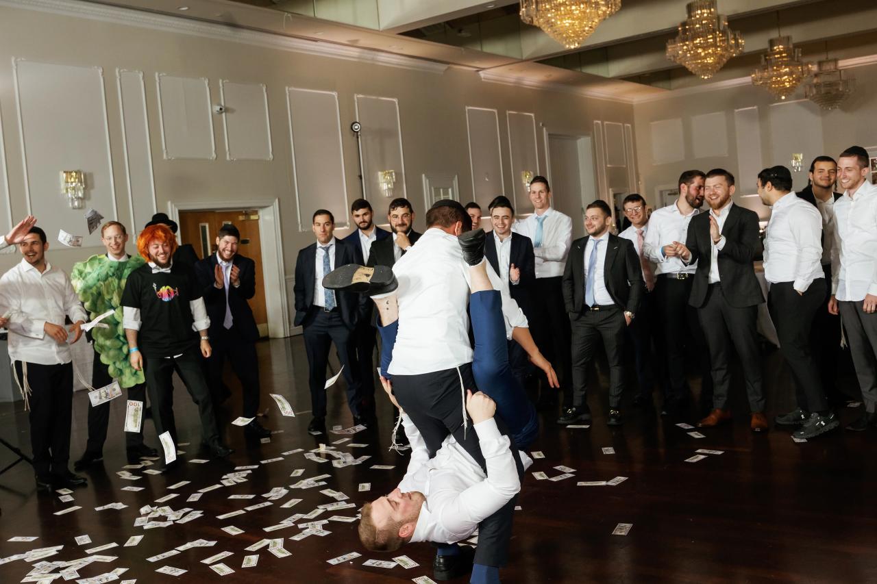 Playful upside-down dance-floor action captured at the peak of the movement. Wedding photography at Ateres Charna, New Square, NY.