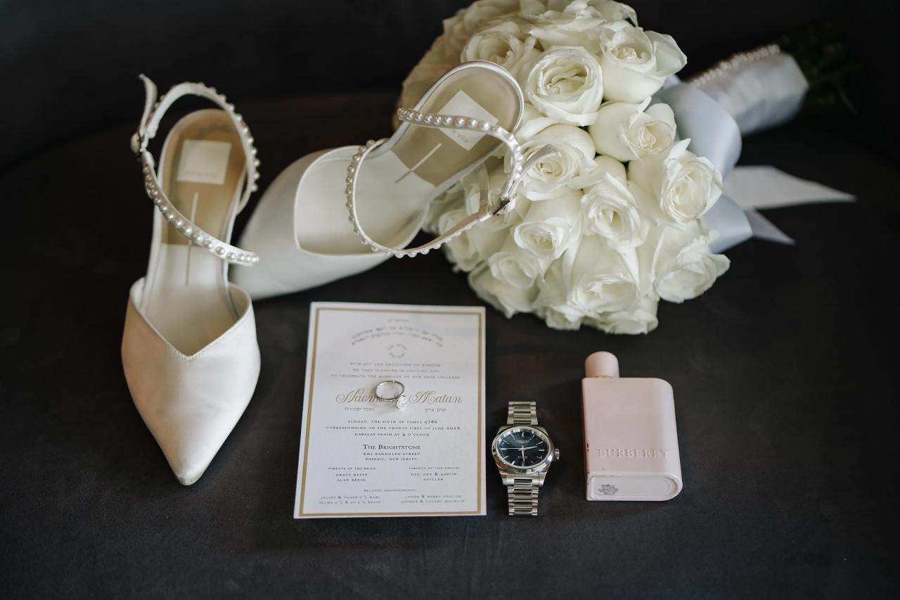 From this Brightstone Hall wedding: white flowers, wedding accessories and stationery arranged in a flat lay. Wedding photography.