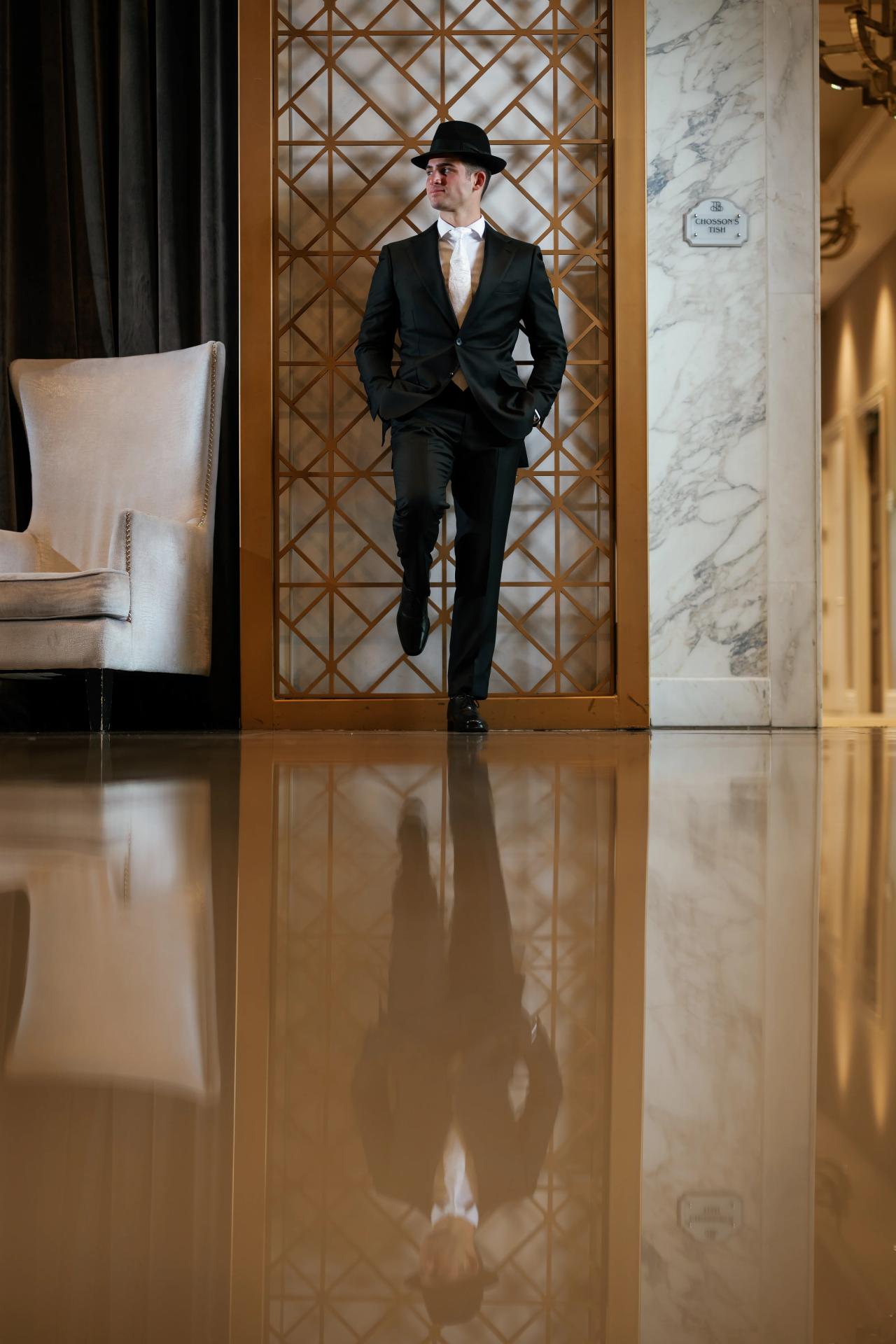 From this Brightstone Hall wedding: black-and-white groom portrait framed by geometric interior screens. Wedding photography.