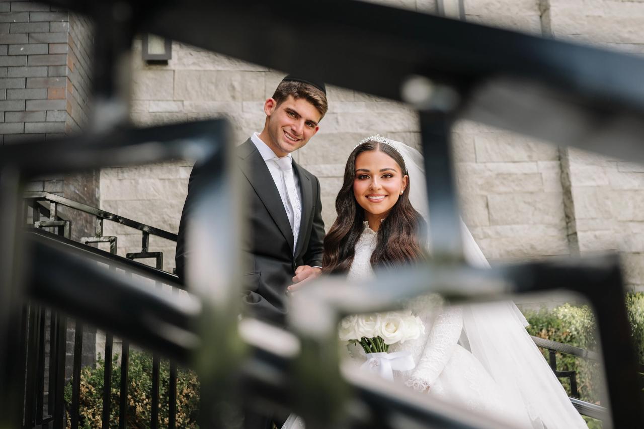Iron railings form a soft geometric foreground around the bride and groom. Wedding photography at Brightstone, Passaic, NJ.