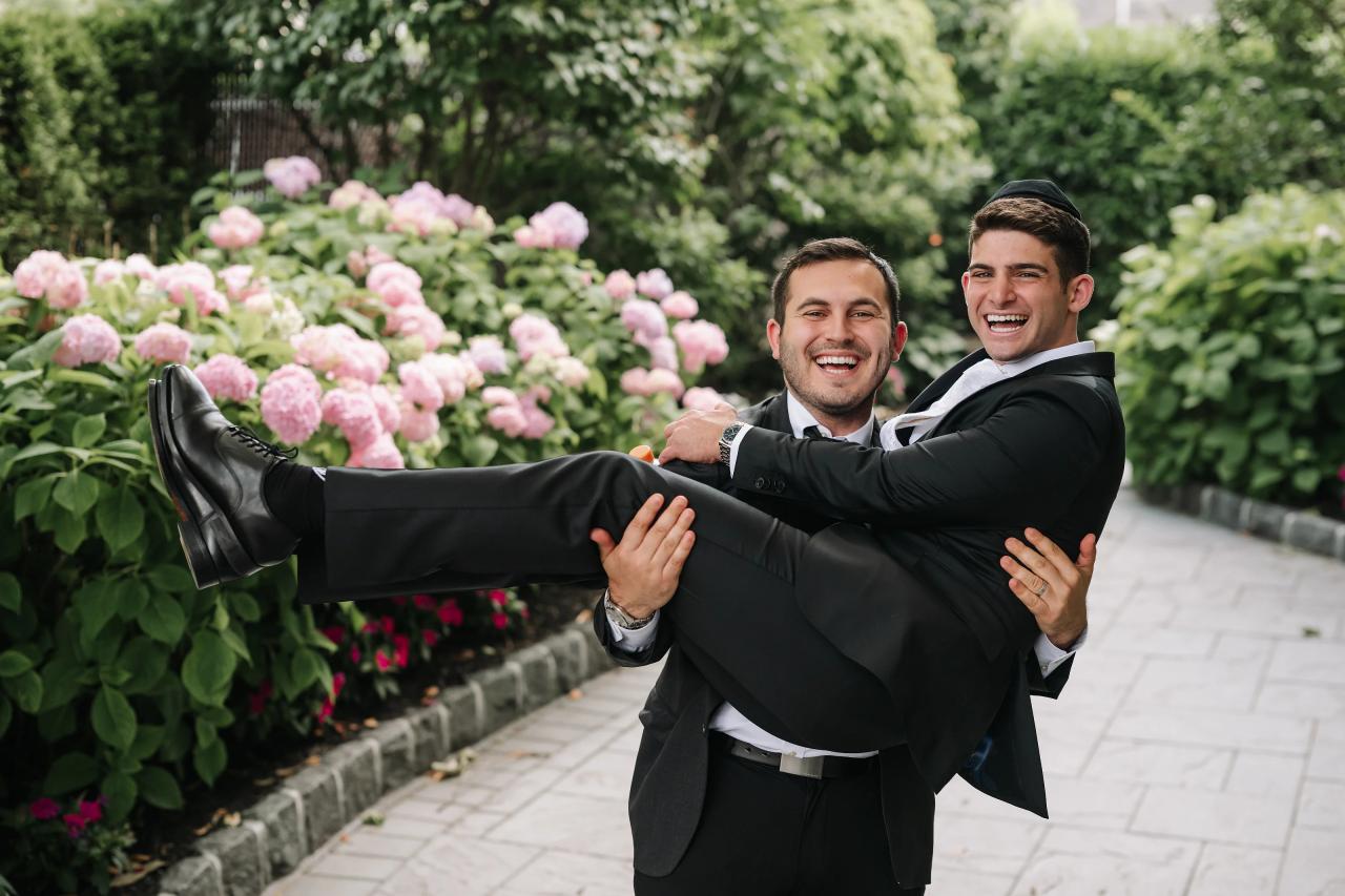 A friend carries the groom outside in a playful wedding moment. Wedding photography at Brightstone, Passaic, NJ.