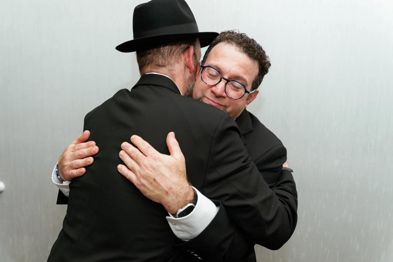 A quiet family embrace before the chuppah. Wedding photography at Brightstone, Passaic, NJ.