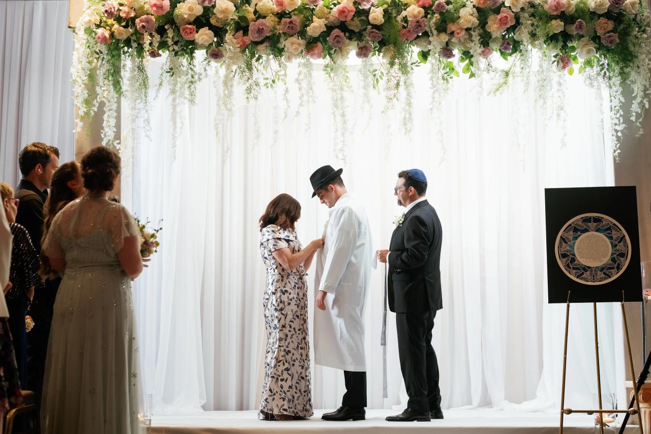 Wide, light-filled chuppah scene with white curtains and hanging flowers. Wedding photography at Brightstone, Passaic, NJ.