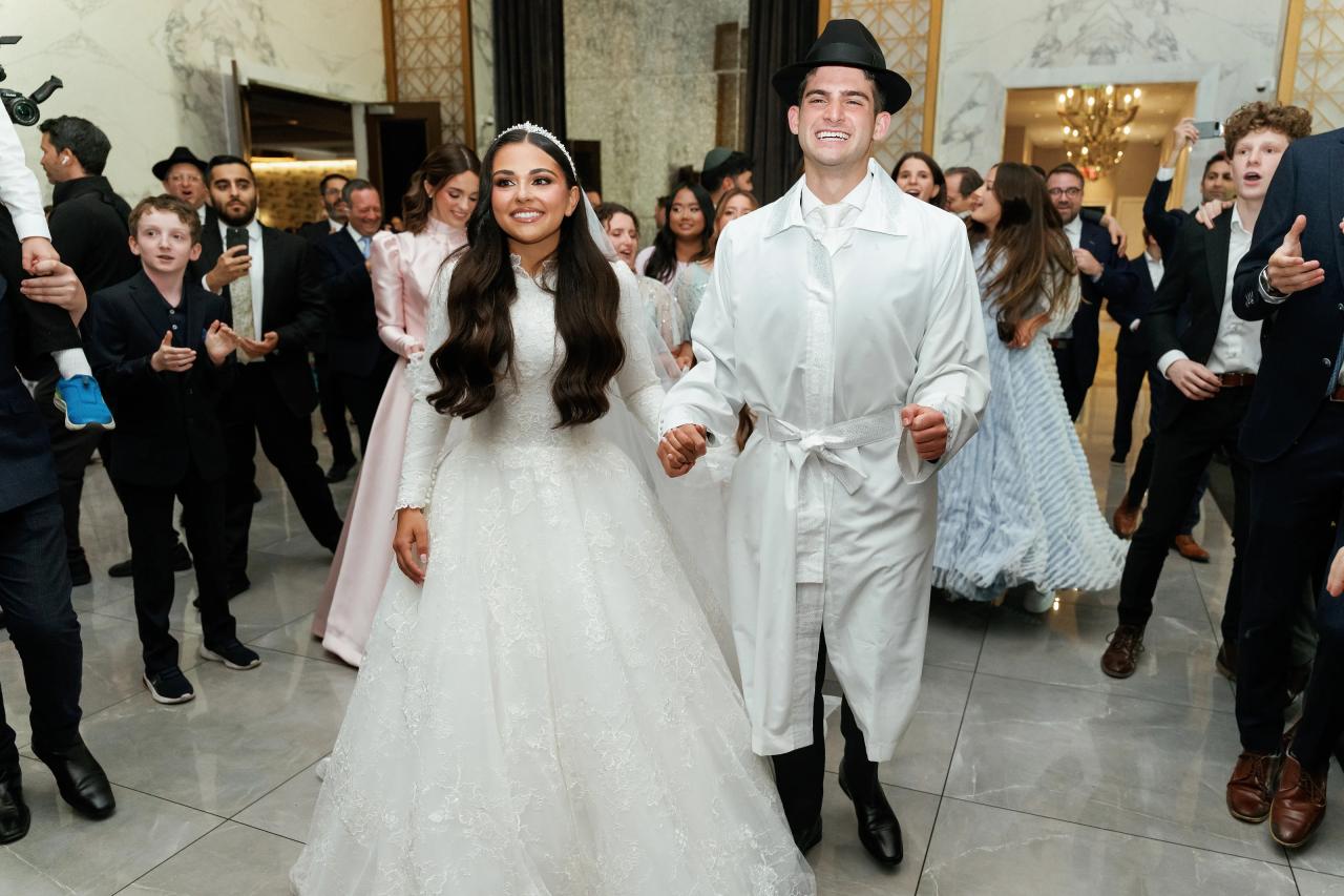The couple leaves the ceremony among smiling guests. Wedding photography at Brightstone, Passaic, NJ.