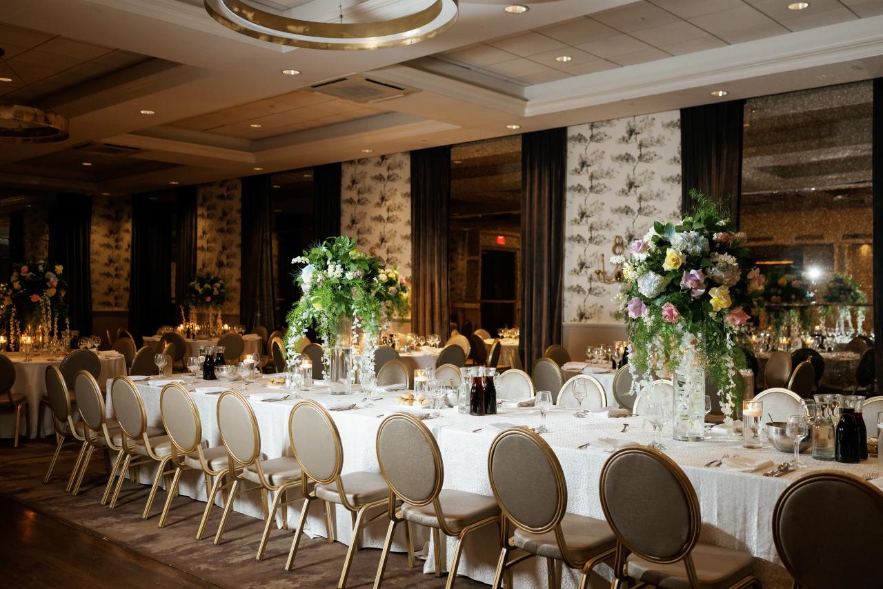 Wide view of the Brightstone Hall reception room with cream chairs and floral tables. Wedding photography.