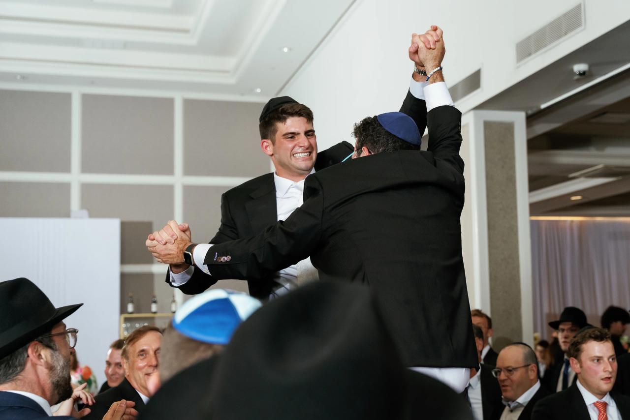 The groom lifted above the celebrating dance crowd. Wedding photography at Brightstone, Passaic, NJ.
