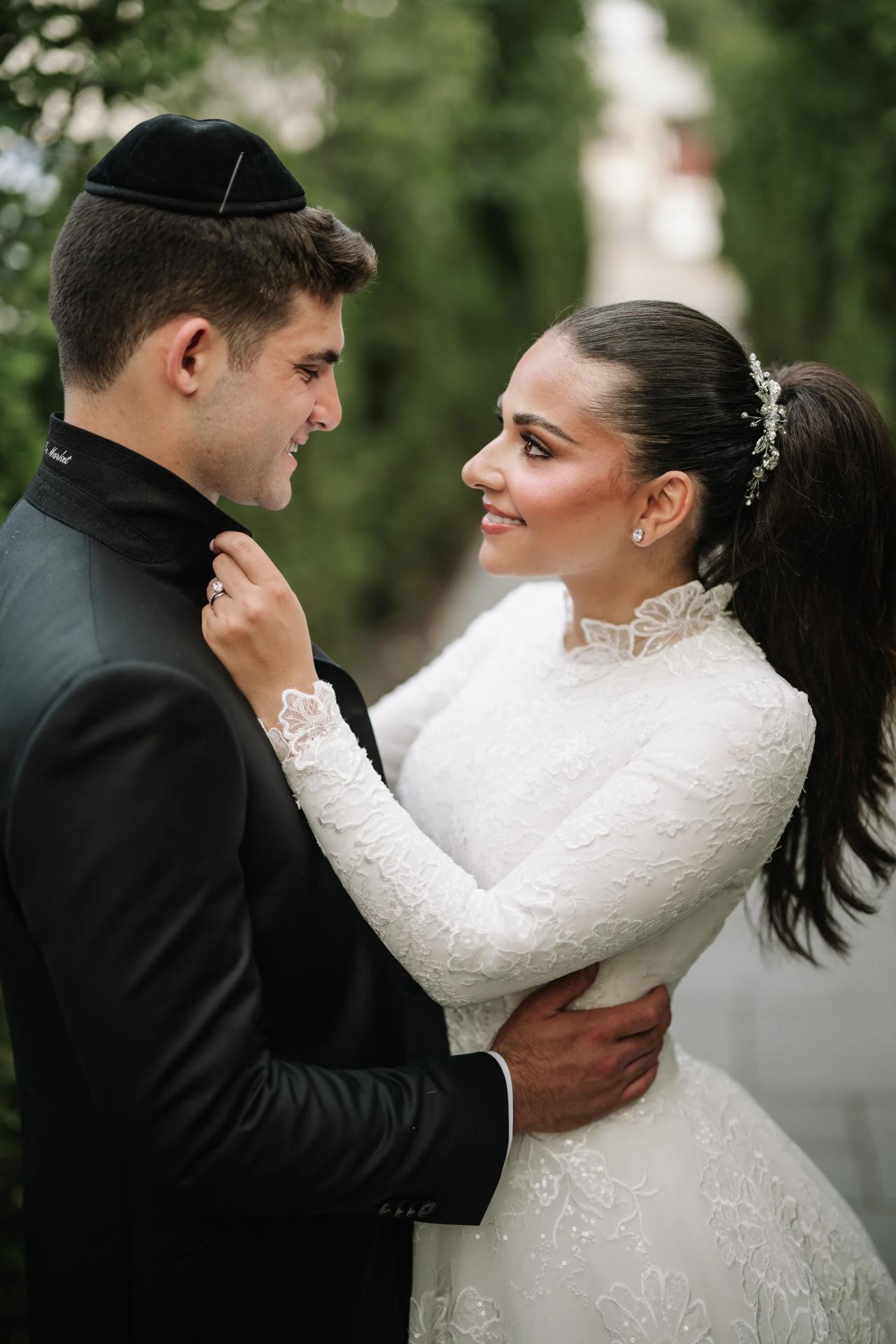 A close portrait of the couple looking at one another with soft green hedges behind them. Wedding photography at Brightstone, Passaic, NJ.
