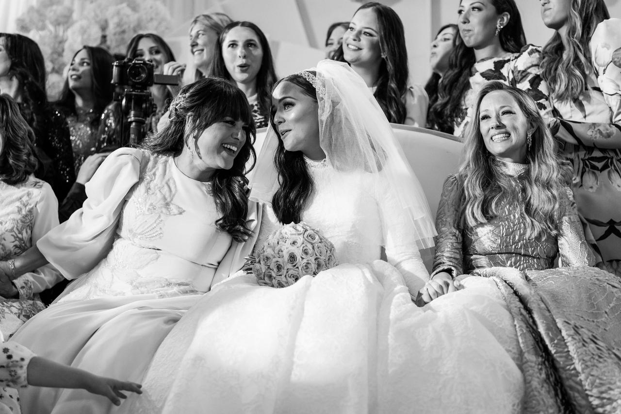 Black-and-white bride and close family laughing together before the chuppah. Wedding photography at Hilton Baltimore Inner Harbor, Baltimore, MD.