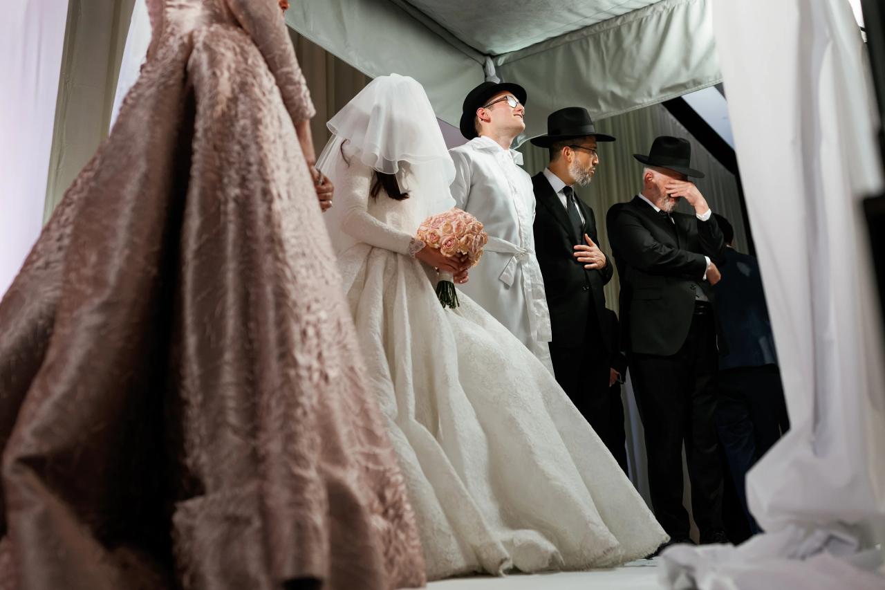 Low intimate angle beneath the chuppah, with the veiled bride and groom looking upward. Wedding photography at Hilton Baltimore Inner Harbor, Baltimore, MD.
