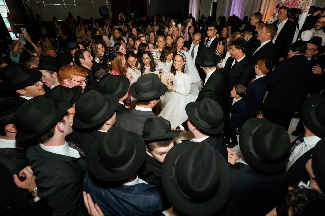 Elevated view of the newlyweds surrounded by a full circle of celebrating friends. Wedding photography at Hilton Baltimore Inner Harbor, Baltimore, MD.