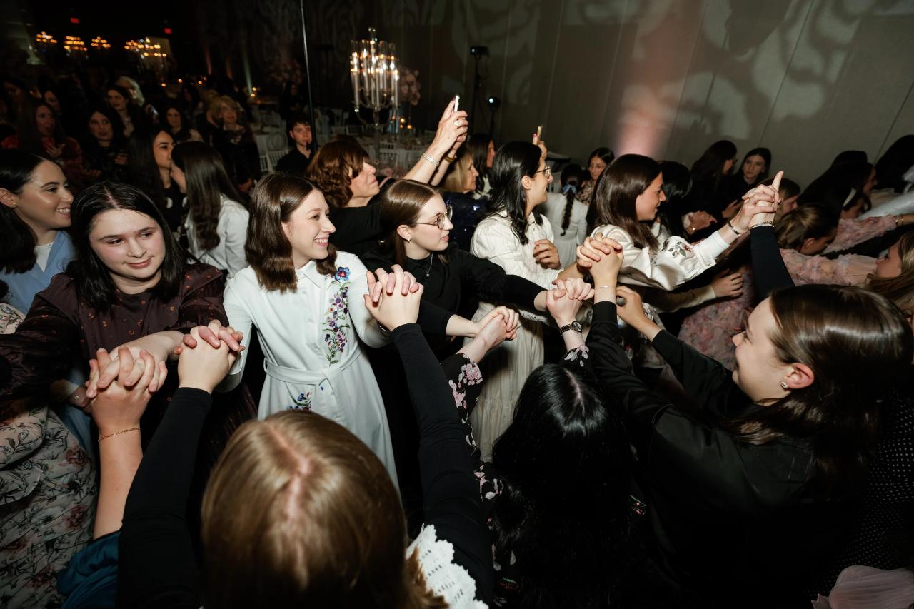 Guests creating a tunnel of joined hands on the dance floor. Wedding photography at Hilton Baltimore Inner Harbor, Baltimore, MD.