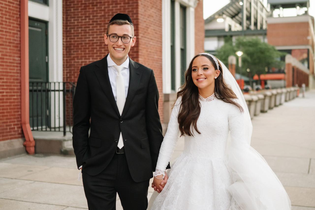 Close walking portrait of the couple, smiling against downtown brick facades — couple portraits for the Hilton Baltimore Inner Harbor wedding. Wedding photography.