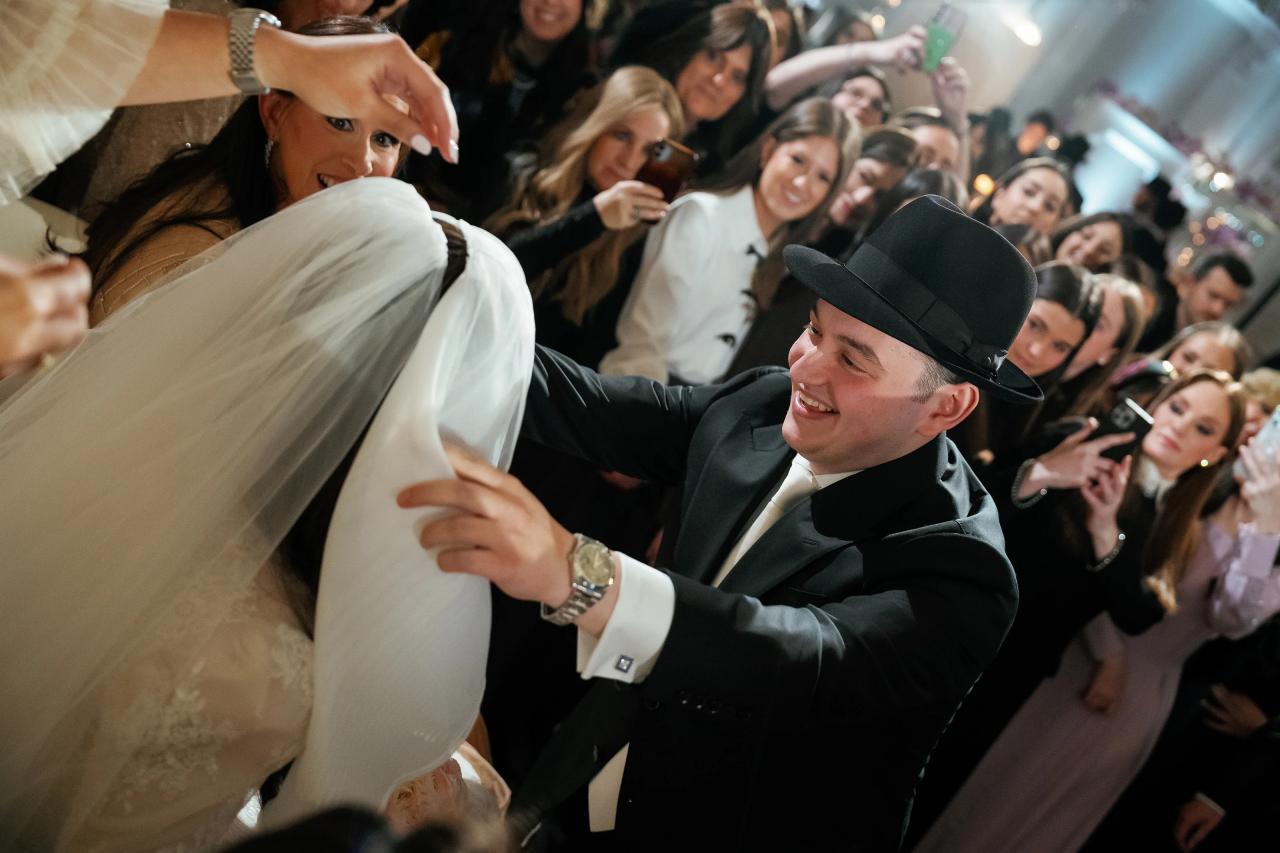 Groom smiling as the bridal veil is lowered during bedeken. Wedding photography at Lake Terrace, Lakewood, NJ.