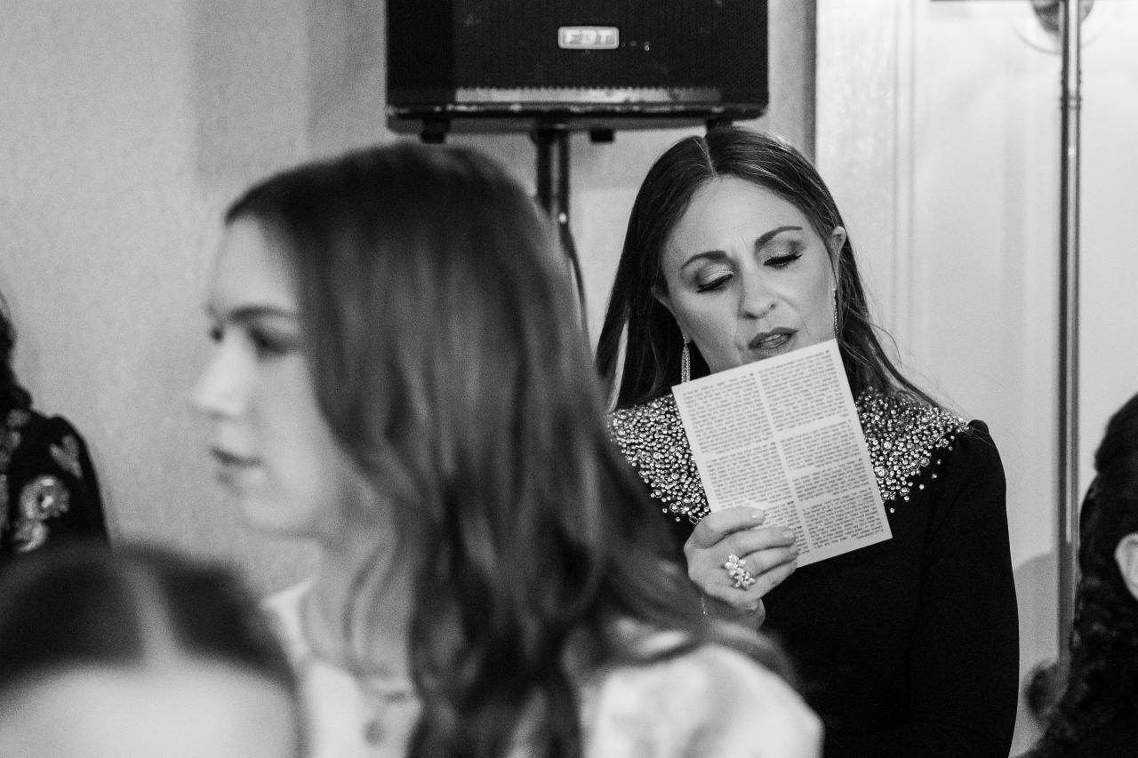Black-and-white guest reading during the wedding ceremony. Wedding photography at Lake Terrace, Lakewood, NJ.