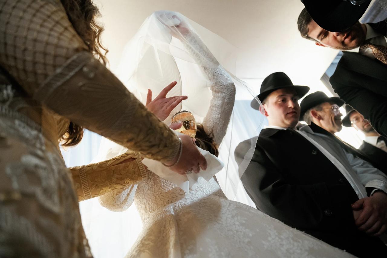 Low-angle ceremony view as the bride raises her veil beside a ceremonial cup. Wedding photography at Lake Terrace, Lakewood, NJ.