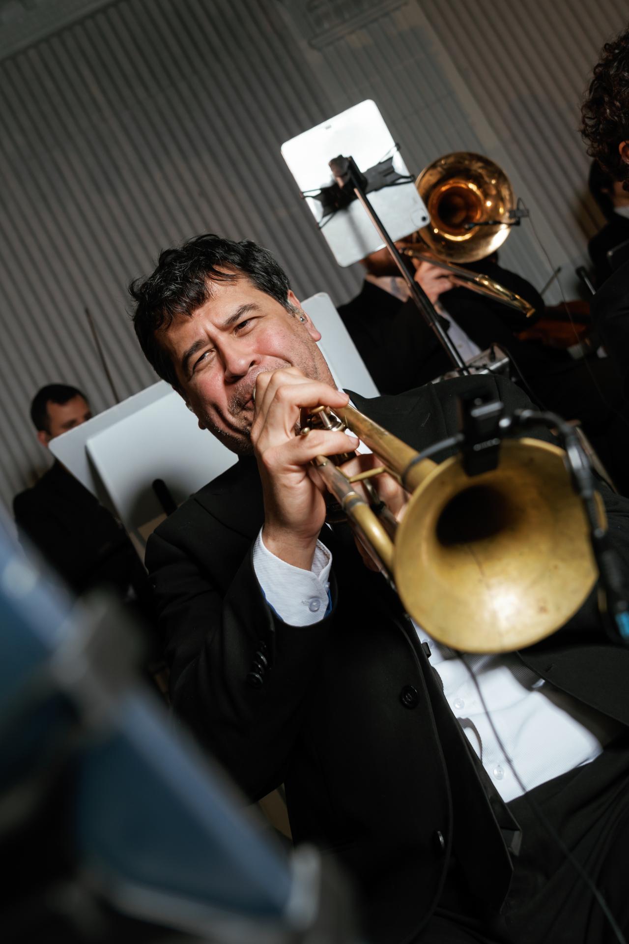 Live trombone player photographed from a close low perspective. Wedding photography at Lake Terrace, Lakewood, NJ.